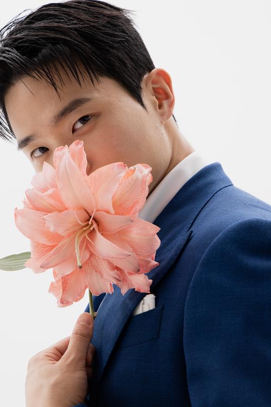 네이비 수트를 입고 꽃을 든 모델